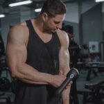 Moderne massagegun in gebruik voor spierherstel na een training, ideaal voor sporters en thuisgebruik.